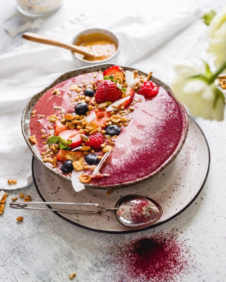 Plum Smoothie Bowl on a table with fresh fruit alongside