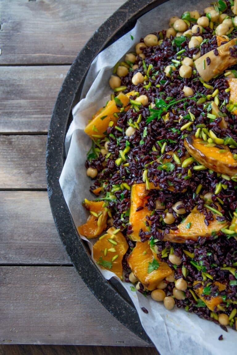 A platter of Roasted Queen Garnet Plum, Pumpkin and Feta salad sitting on a wooden tabletop